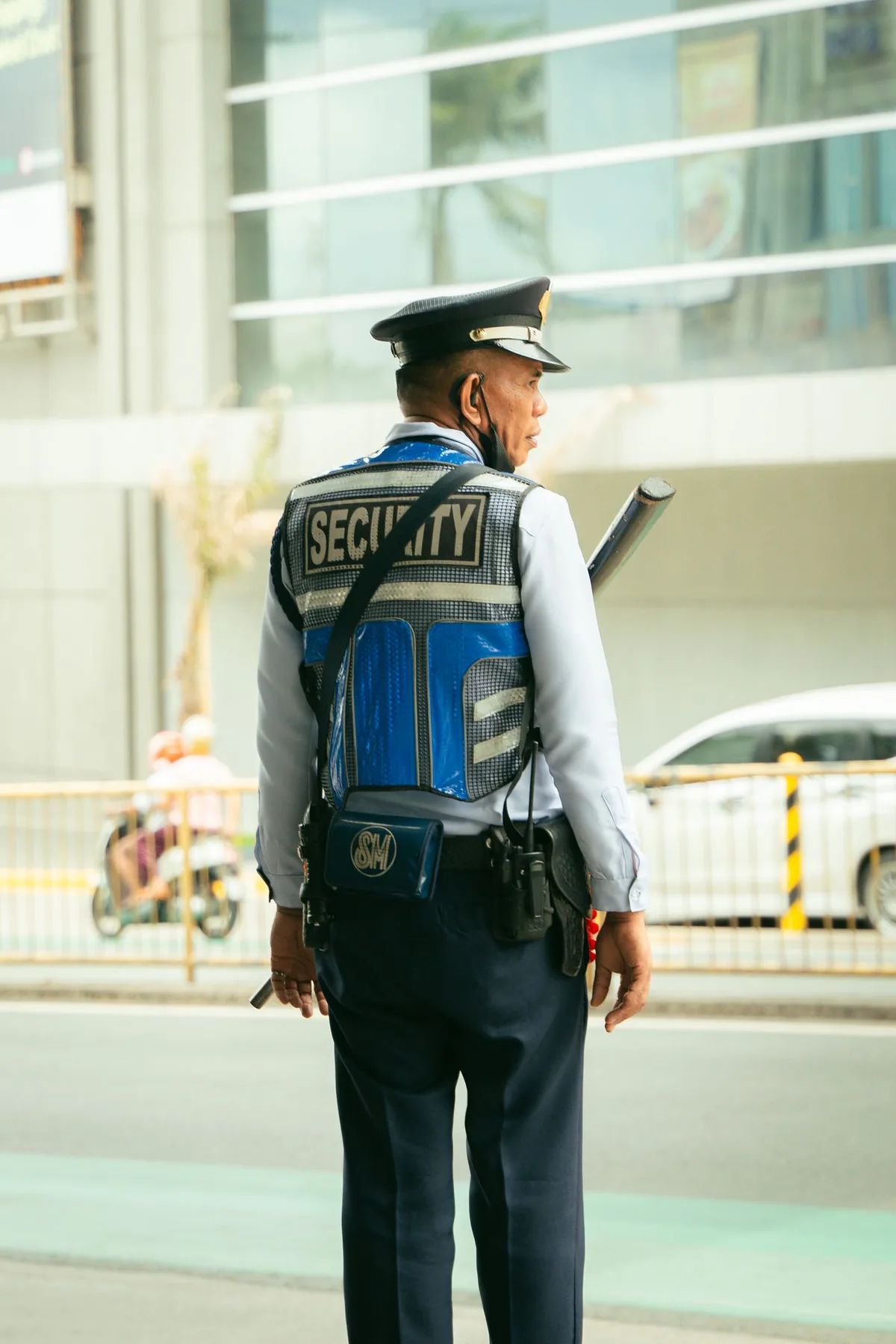 Security officer on patrol carrying a two-way radio outside a commercial building